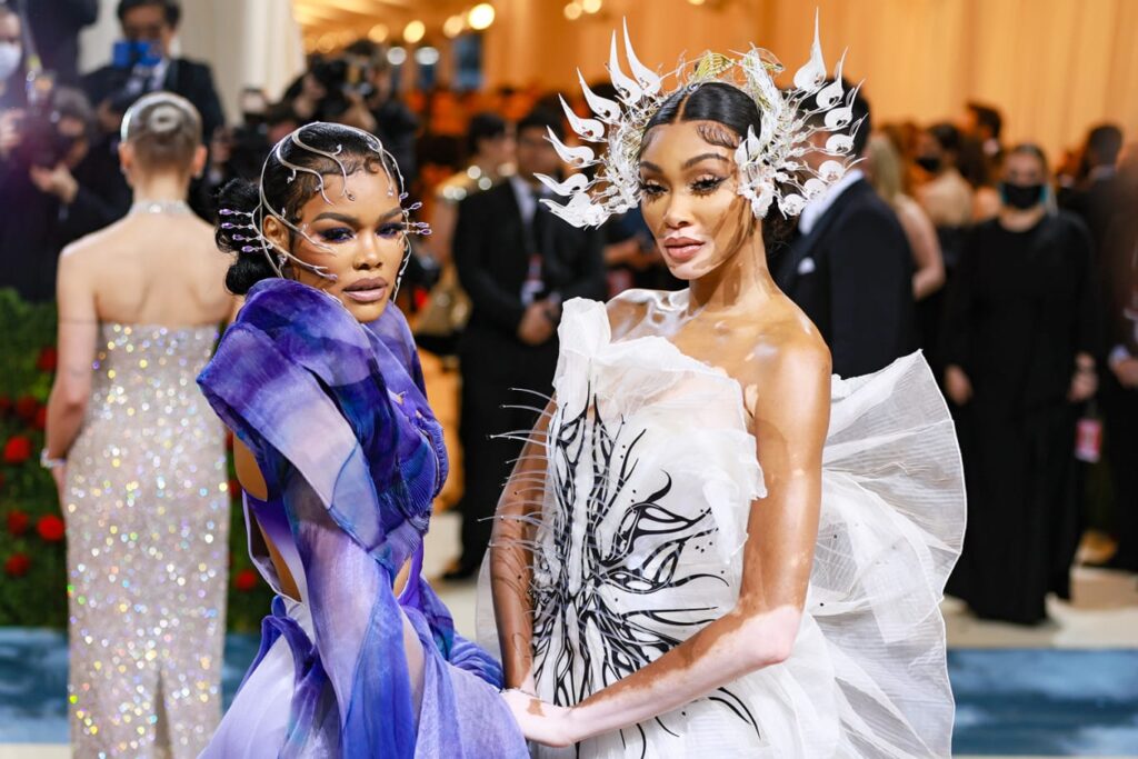 Winnie Harlow and Teyana Taylor dazzled in Iris van Herpen ensembles and headpieces. Harlow opted for a black-and-white sculptural dress, while Taylor wore a gauzy purple gown. Taylor told Vogue on the red carpet that it was a "futuristic" take on the "Gilded Glamour" theme but also like the villain Ursula from "The Little Mermaid." Credit: Theo Wargo/WireImage/Getty Images