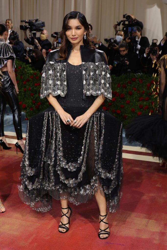 With her outfit and jewelry both designed by Louis Vuitton, actress Gemma Chan arrived in a crystal-embellished leather cape and a dress with theatrically exaggerated hips. Credit: Mike Coppola/Getty Images